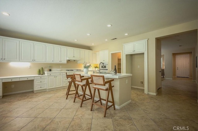 25217 Pacific Crest St, Corona, CA 92883 - kitchen with gas stovetop, light countertops, recessed lighting, white cabinetry, and under cabinet range hood