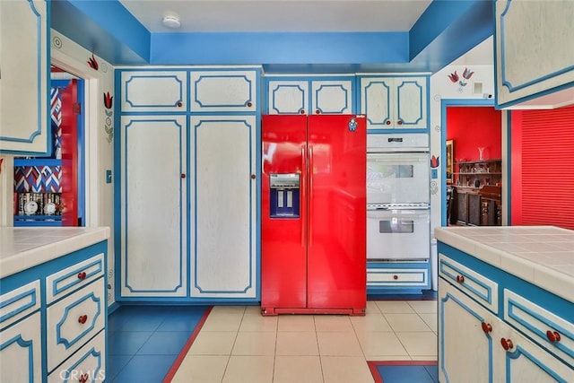 17313 Citronia St, Northridge, CA 91325 - kitchen featuring high end refrigerator, white double oven, tile countertops, and light tile patterned floors