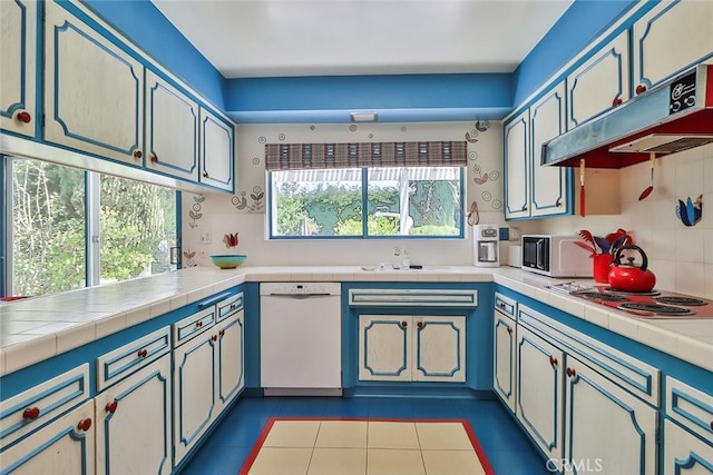 17313 Citronia St, Northridge, CA 91325 - kitchen featuring dishwasher, under cabinet range hood, light tile patterned floors, backsplash, and electric cooktop