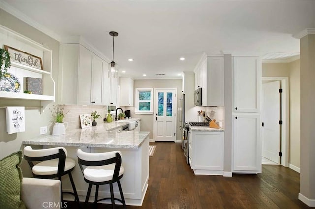 6541 Tokay Rd, Tujunga, CA 91042 - kitchen featuring stainless steel appliances, white cabinets, backsplash, light stone counters, and a peninsula