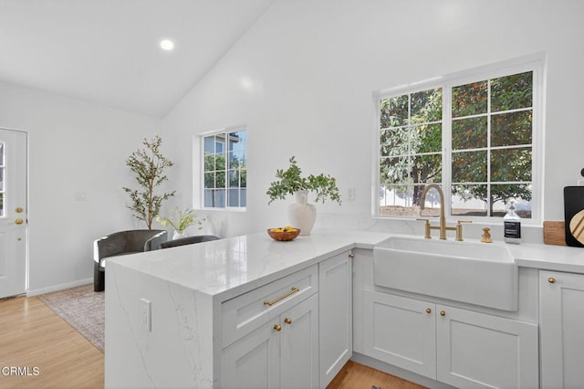 221 N 7th St, Santa Paula, CA 93060 - kitchen featuring light stone counters, light wood-type flooring, a peninsula, recessed lighting, and white cabinets