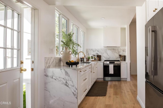 221 N 7th St, Santa Paula, CA 93060 - kitchen with high end fridge, stainless steel range oven, light stone countertops, light wood-type flooring, and healthy amount of natural light