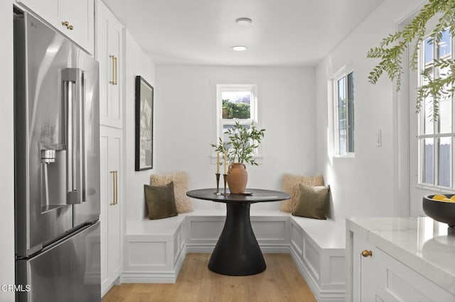 221 N 7th St, Santa Paula, CA 93060 - dining space featuring plenty of natural light, light wood-style flooring, a decorative wall, and wainscoting