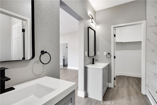 1671 Sweetbriar Ln, Paradise, CA 95969 - bathroom featuring a textured wall, wood finished floors, and two vanities