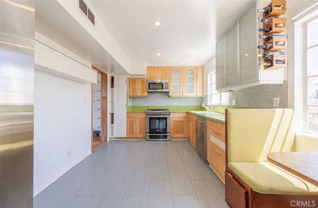 750 S Windsor Blvd Unit 7, Los Angeles, CA 90005 - kitchen with stainless steel appliances, tasteful backsplash, glass insert cabinets, recessed lighting, and light countertops