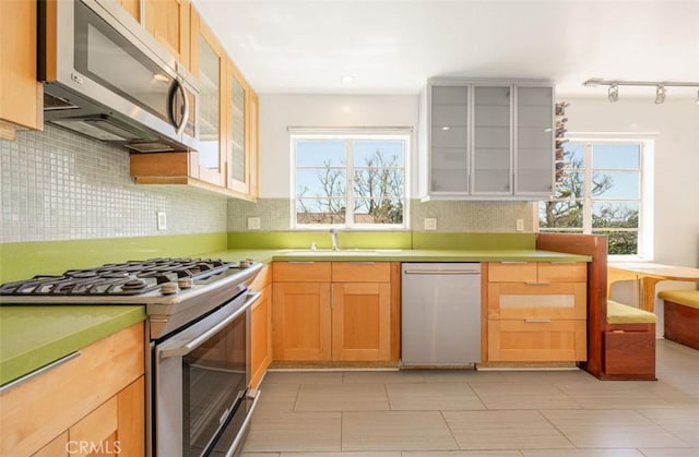 750 S Windsor Blvd Unit 7, Los Angeles, CA 90005 - kitchen with appliances with stainless steel finishes, plenty of natural light, tasteful backsplash, and glass insert cabinets