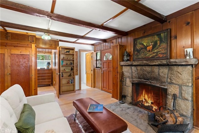 27917 Squirrel Ln, Lake Arrowhead, CA 92352 - living area featuring healthy amount of natural light, wooden walls, light wood-type flooring, beam ceiling, and a stone fireplace