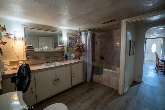 22731 Bryman Rd, Oro Grande, CA 92368 - bathroom with wood finished floors, a textured ceiling, vanity, and tiled shower / bath combo