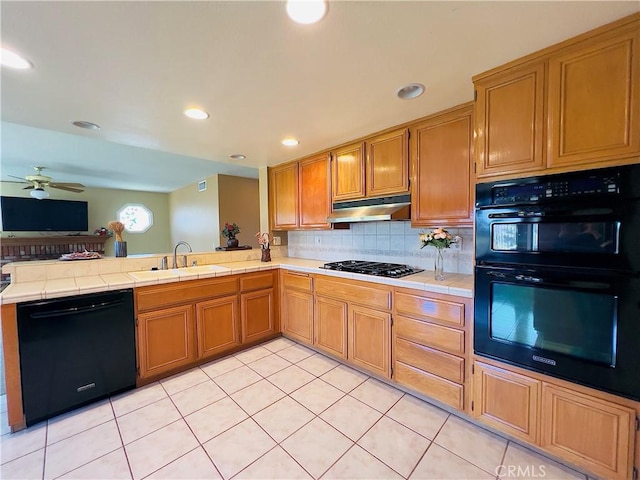 17346 Cold Spring Cir, Riverside, CA 92503 - kitchen with black appliances, tile counters, under cabinet range hood, light tile patterned flooring, and recessed lighting