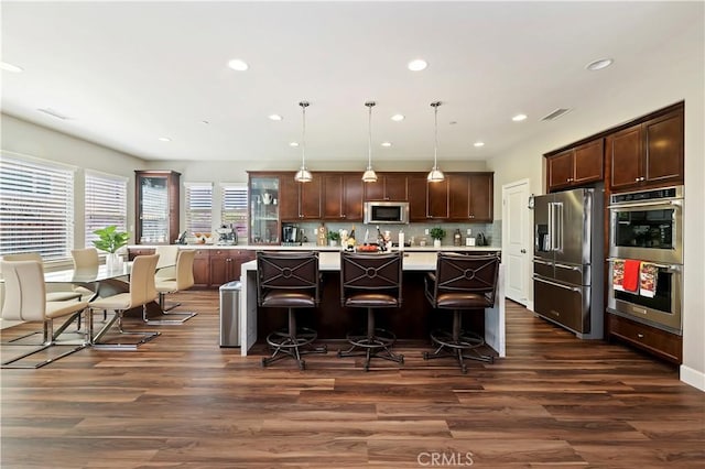 27843 Huron Ct, Menifee, CA 92585 - kitchen featuring stainless steel appliances, light countertops, dark brown cabinets, dark wood finished floors, and a center island