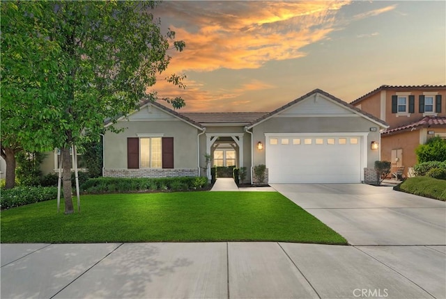 27843 Huron Ct, Menifee, CA 92585 - view of front of property featuring concrete driveway, an attached garage, stucco siding, a lawn, and brick siding