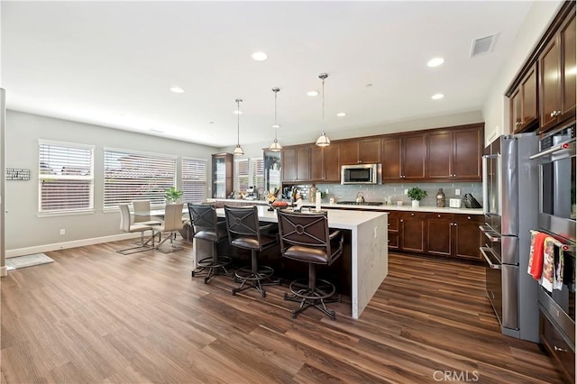 27843 Huron Ct, Menifee, CA 92585 - kitchen featuring stainless steel appliances, light countertops, dark wood-style flooring, backsplash, and recessed lighting