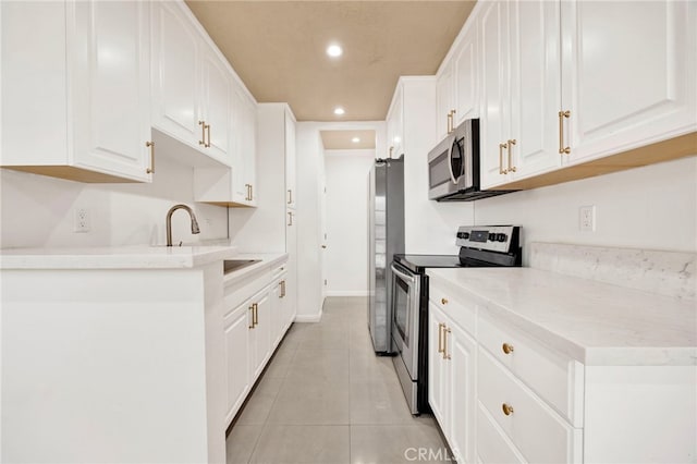 5320 Zelzah Ave Unit 106, Encino, CA 91316 - kitchen with appliances with stainless steel finishes, light tile patterned flooring, white cabinetry, recessed lighting, and light countertops