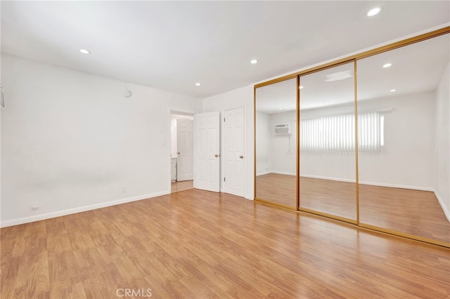 5320 Zelzah Ave Unit 106, Encino, CA 91316 - unfurnished bedroom with light wood-type flooring, a wall unit AC, recessed lighting, and a closet