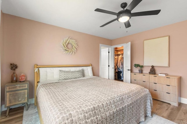 3585 Redwood St, San Diego, CA 92104 - bedroom featuring light wood-type flooring, a walk in closet, a closet, and a ceiling fan