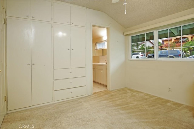 13924 2nd St, Whittier, CA 90605 - unfurnished bedroom with light colored carpet, ensuite bathroom, lofted ceiling, a closet, and a textured ceiling