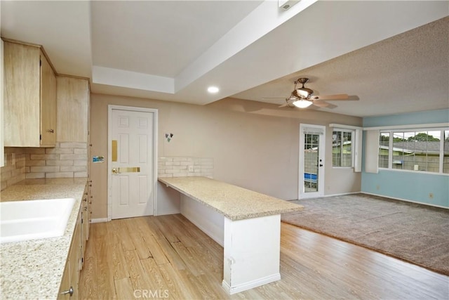 13924 2nd St, Whittier, CA 90605 - kitchen with a peninsula, backsplash, light brown cabinetry, light wood-style flooring, and ceiling fan