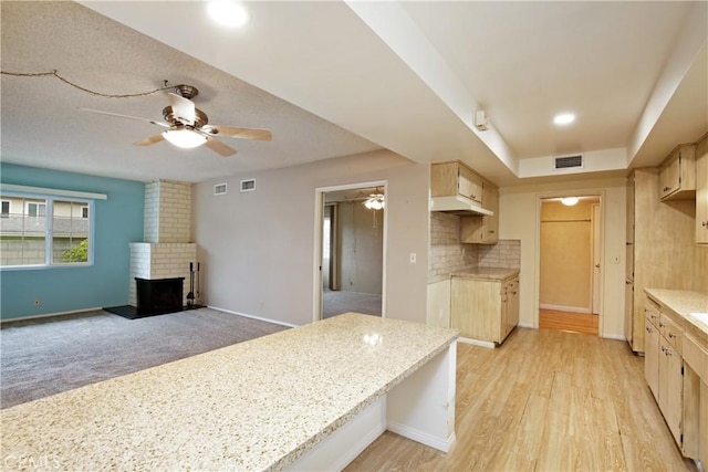 13924 2nd St, Whittier, CA 90605 - kitchen featuring a ceiling fan, under cabinet range hood, a brick fireplace, backsplash, and light brown cabinets