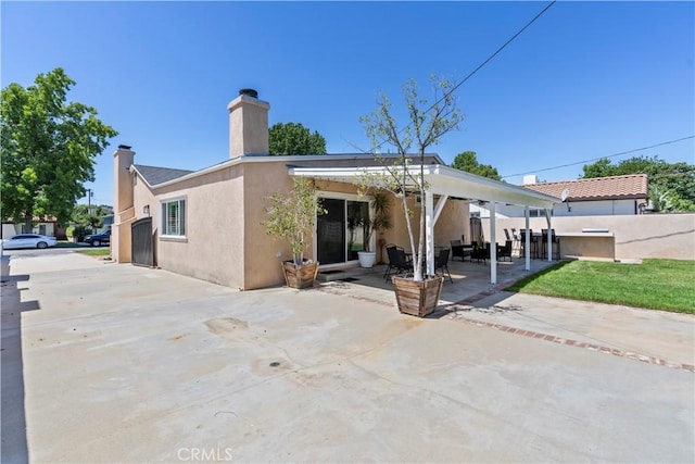 15037 Hiawatha St, Mission Hills San Fernando, CA 91345 - back of house featuring a chimney, a patio area, and stucco siding
