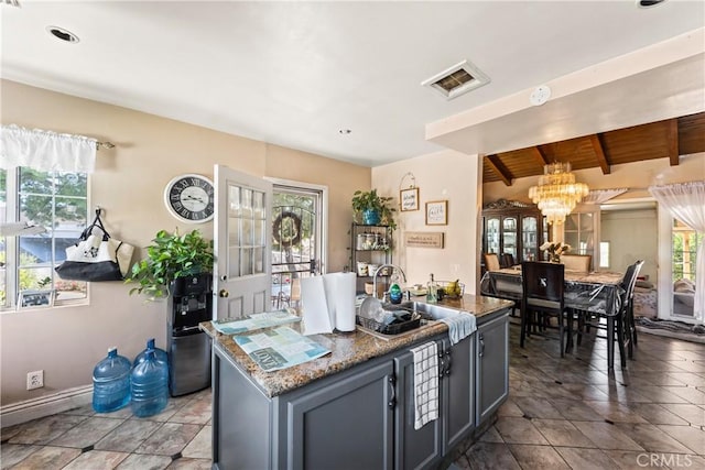 822 Corona Ave, Corona, CA 92879 - kitchen featuring a chandelier, a kitchen island, light tile patterned floors, stone counters, and beam ceiling