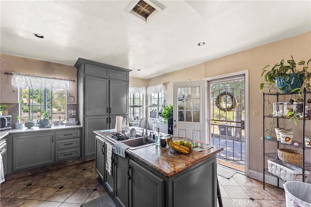 822 Corona Ave, Corona, CA 92879 - kitchen with stainless steel microwave, gray cabinetry, a kitchen island with sink, light tile patterned flooring, and recessed lighting