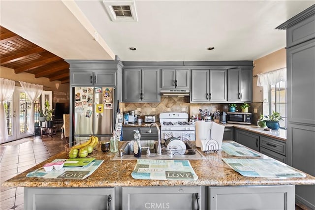 822 Corona Ave, Corona, CA 92879 - kitchen featuring stainless steel appliances, gray cabinets, under cabinet range hood, light stone countertops, and backsplash