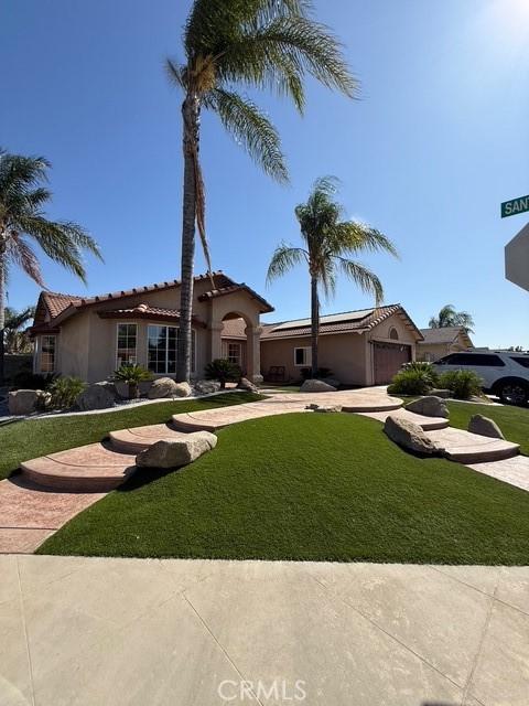513 Chianti Ct, Madera, CA 93637 - mediterranean / spanish-style home featuring driveway, a front yard, a tile roof, and stucco siding