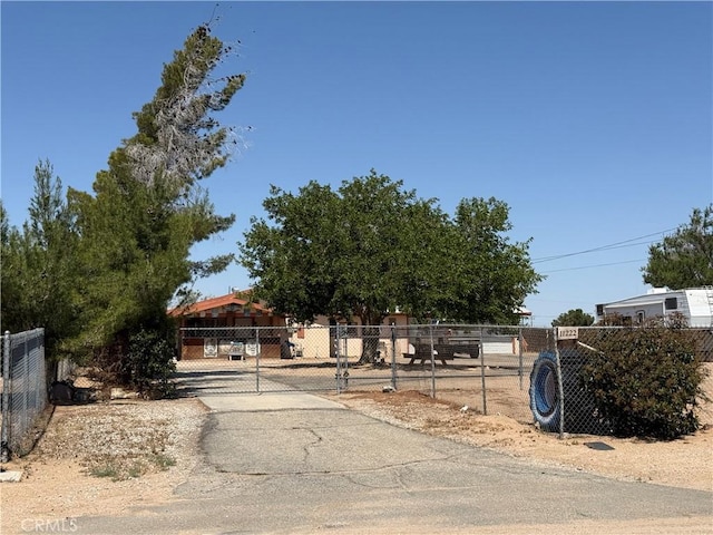 11222 Pinon Ave, Hesperia, CA 92345 - view of property hidden behind natural elements featuring driveway and a gate