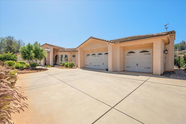 29861 Kirsten Ln, Vista, CA 92084 - mediterranean / spanish-style home with driveway, an attached garage, a tiled roof, and stucco siding