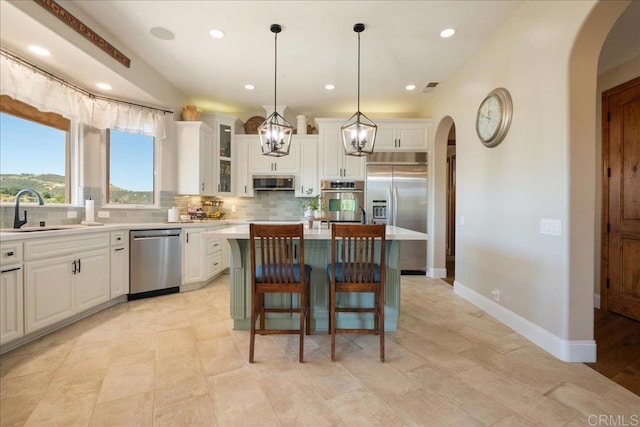 29861 Kirsten Ln, Vista, CA 92084 - kitchen with appliances with stainless steel finishes, arched walkways, tasteful backsplash, a center island, and recessed lighting