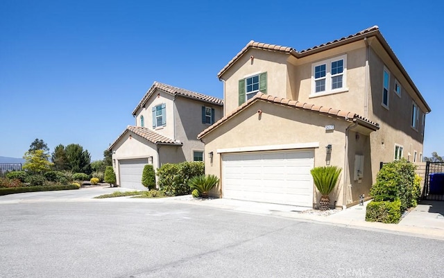 26370 Piazza Di Sarro, Newhall, CA 91321 - mediterranean / spanish home featuring a garage, a tiled roof, and stucco siding