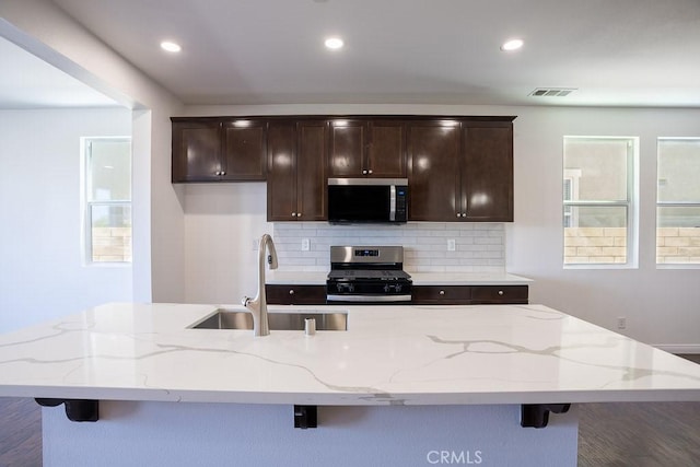 26370 Piazza Di Sarro, Newhall, CA 91321 - kitchen with appliances with stainless steel finishes, decorative backsplash, a breakfast bar, and recessed lighting
