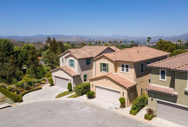 26370 Piazza Di Sarro, Newhall, CA 91321 - mediterranean / spanish home with stucco siding, an attached garage, a tile roof, a mountain view, and driveway
