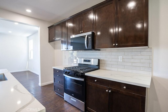 26370 Piazza Di Sarro, Newhall, CA 91321 - kitchen featuring appliances with stainless steel finishes, backsplash, dark wood-style floors, light stone countertops, and dark brown cabinets