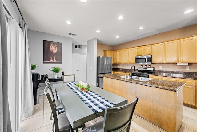 3260 Ivy Ct, Perris, CA 92571 - kitchen with stainless steel appliances, light brown cabinetry, a center island with sink, recessed lighting, and dark stone countertops