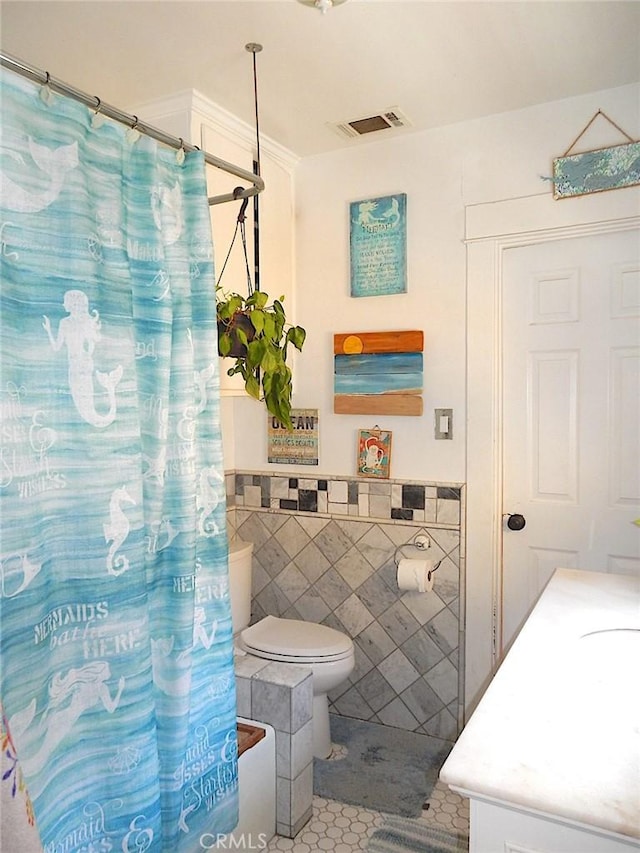 2616 S Denison Ave, San Pedro, CA 90731 - bathroom featuring tile walls, vanity, tile patterned flooring, curtained shower, and wainscoting