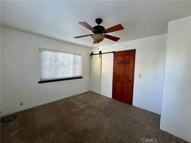31016 Summit Dr, Running Springs, CA 92382 - unfurnished bedroom with carpet flooring, ceiling fan, and a barn door