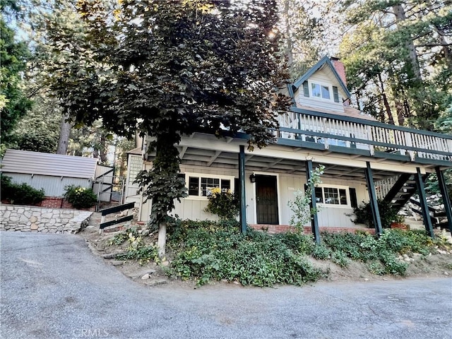 31016 Summit Dr, Running Springs, CA 92382 - view of front of home with stairs, board and batten siding, a wooden deck, and a chimney