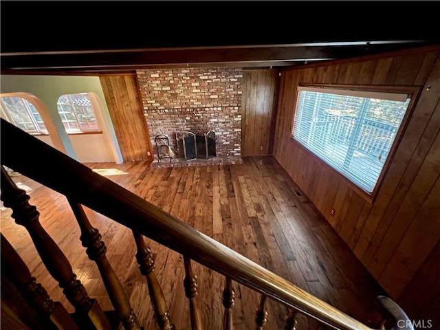 31016 Summit Dr, Running Springs, CA 92382 - unfurnished living room with wood walls, hardwood / wood-style floors, and a brick fireplace