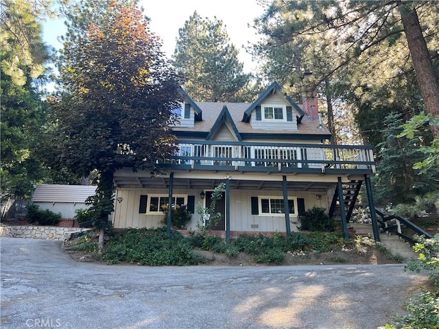 31016 Summit Dr, Running Springs, CA 92382 - view of front of house with a wooden deck, board and batten siding, stairs, and a chimney