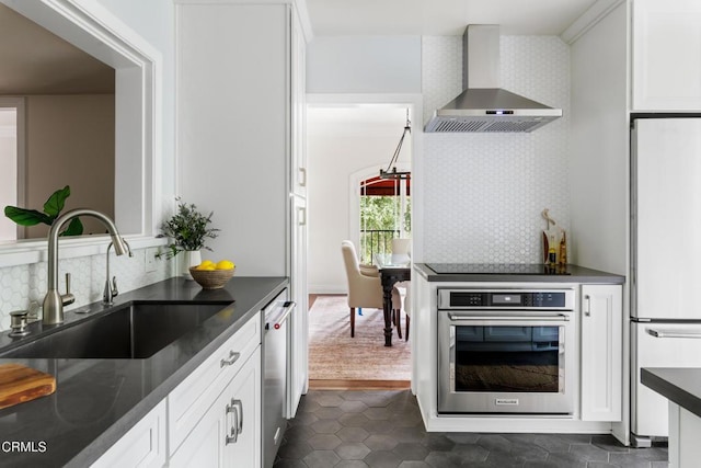 413 Sycamore Pl, Sierra Madre, CA 91024 - kitchen with wall chimney exhaust hood, stainless steel appliances, dark countertops, and white cabinetry