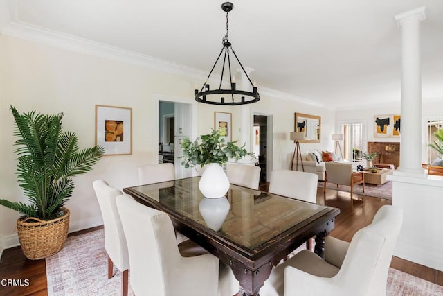 413 Sycamore Pl, Sierra Madre, CA 91024 - dining space with ornate columns, a chandelier, crown molding, and wood finished floors