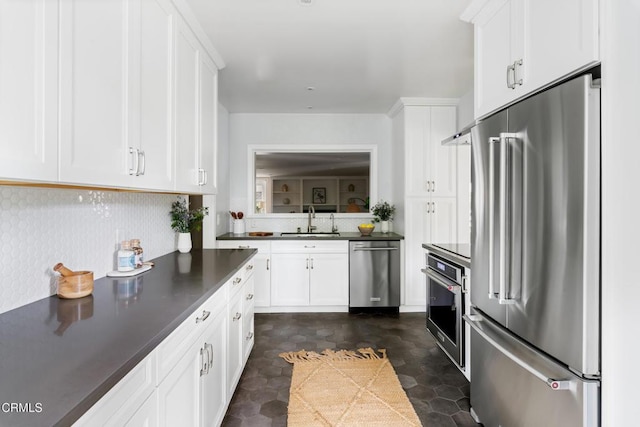 413 Sycamore Pl, Sierra Madre, CA 91024 - kitchen featuring appliances with stainless steel finishes, dark countertops, white cabinetry, and tasteful backsplash