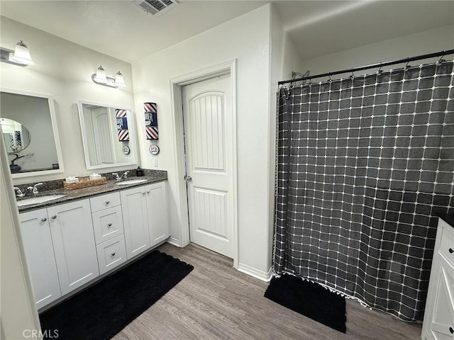 27265 Graphite Dr, Menifee, CA 92584 - full bathroom featuring wood finished floors, double vanity, and tiled shower
