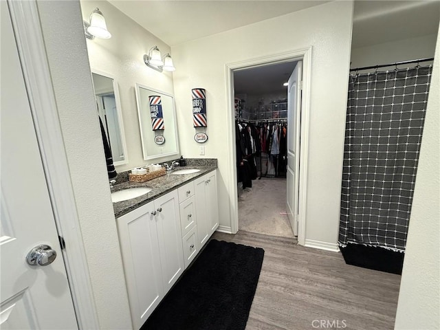 27265 Graphite Dr, Menifee, CA 92584 - full bath featuring double vanity, wood finished floors, a walk in closet, and a shower with curtain