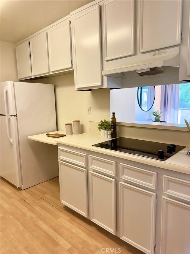570 Peach St Unit 25, San Luis Obispo, CA 93401 - kitchen featuring freestanding refrigerator, light countertops, light wood finished floors, and white cabinetry
