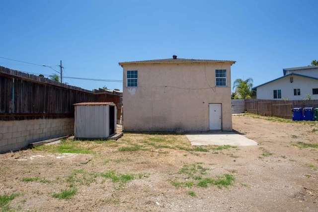 5412 Cervantes Ave, San Diego, CA 92114 - rear view of property with a fenced backyard, stucco siding, and a storage unit