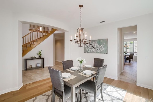 15240 Cayenne Creek Ct, San Diego, CA 92127 - dining area featuring stairs, a chandelier, light wood finished floors, and arched walkways