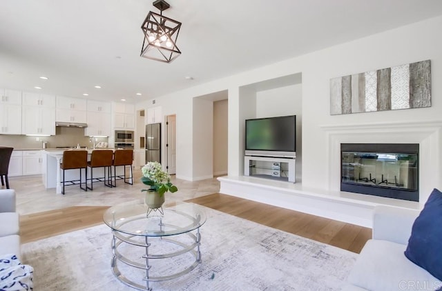 15240 Cayenne Creek Ct, San Diego, CA 92127 - living area featuring light wood-type flooring, recessed lighting, and a glass covered fireplace