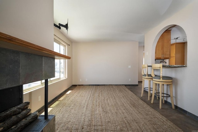 5155 W Point Loma Blvd Unit 9, San Diego, CA 92107 - unfurnished living room featuring arched walkways and dark colored carpet